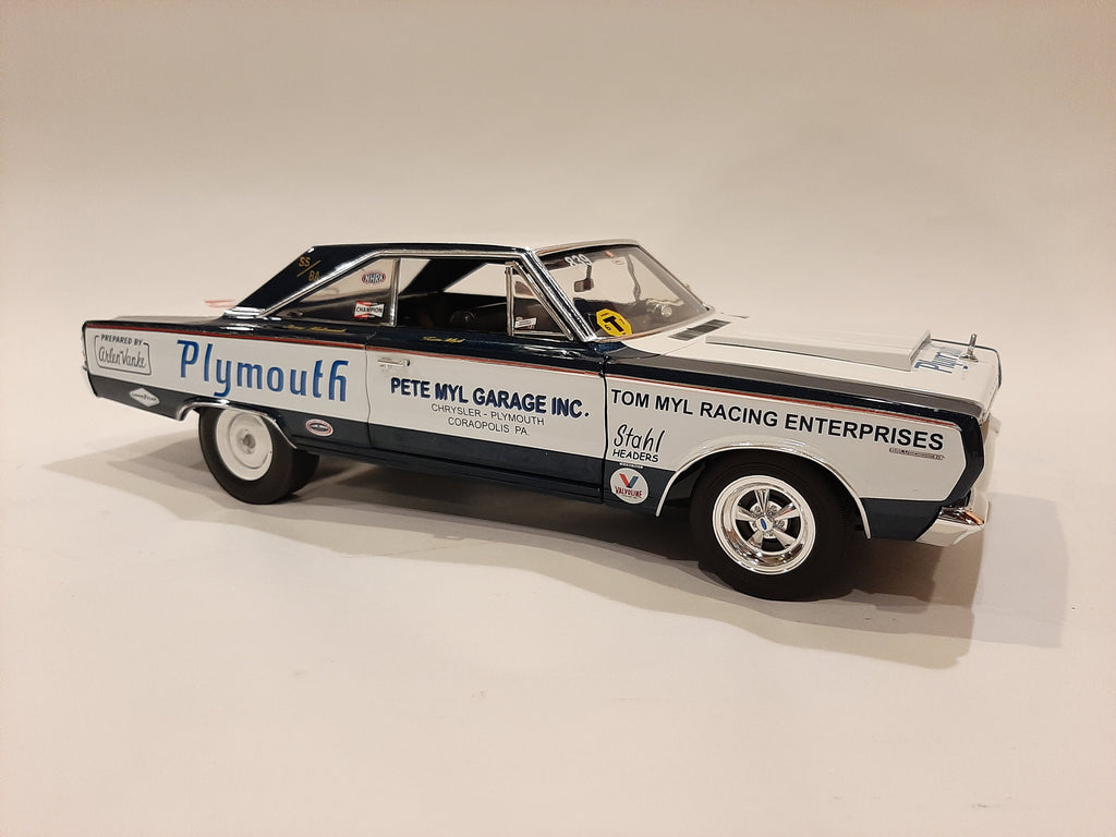 A 1/18 scale model of a 1967 Plymouth Belvedere in white with blue and black detailing, resembling a racing car with sponsor decals.