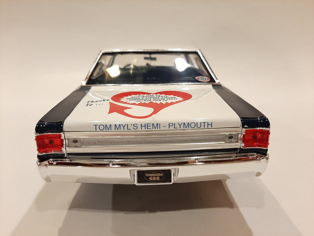 A 1/18 scale model of a 1967 Plymouth Belvedere in white with blue and black detailing, resembling a racing car with sponsor decals.