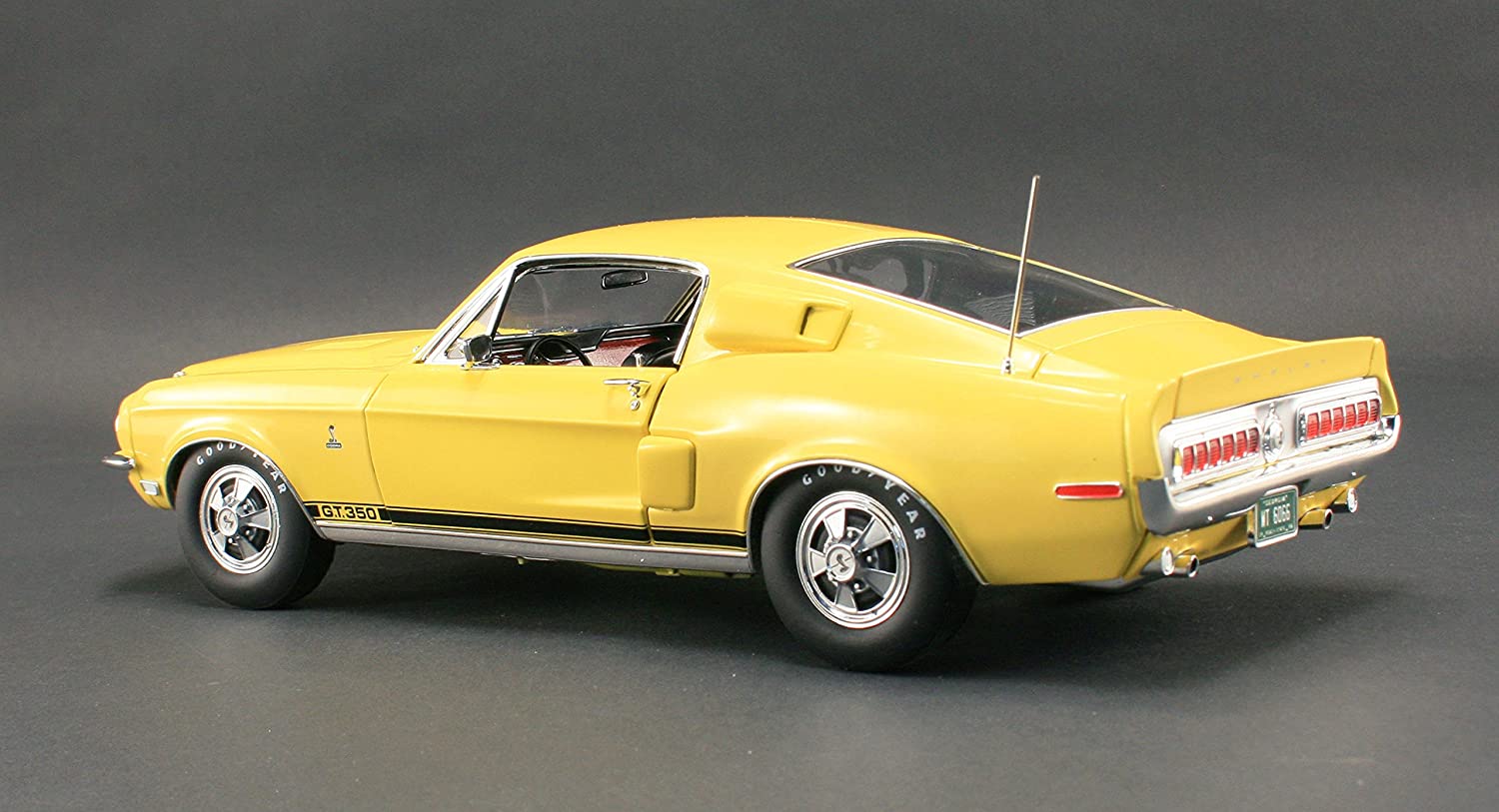 A 1/18 scale model of a yellow 1968 Ford Shelby GT350 Coupe.