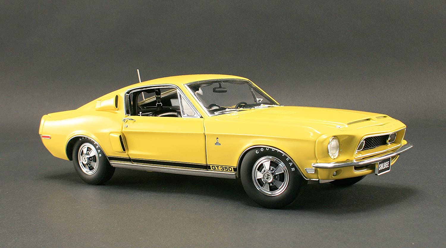 A 1/18 scale model of a yellow 1968 Ford Shelby GT350 Coupe.