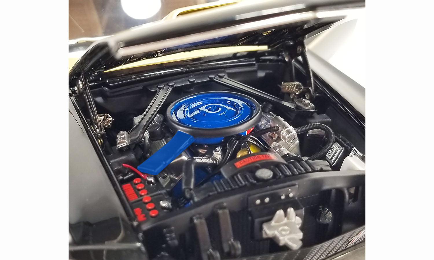A close up of under the hood of a diecast model car.