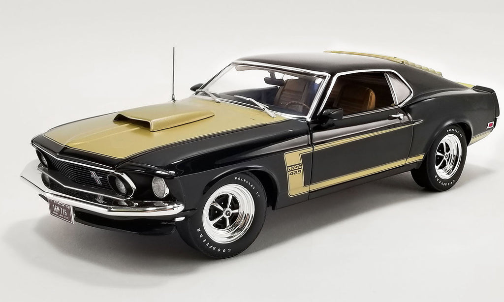 A 1/18 scale diecast model car of a black and gold 1969 Ford Mustang Boss 429.