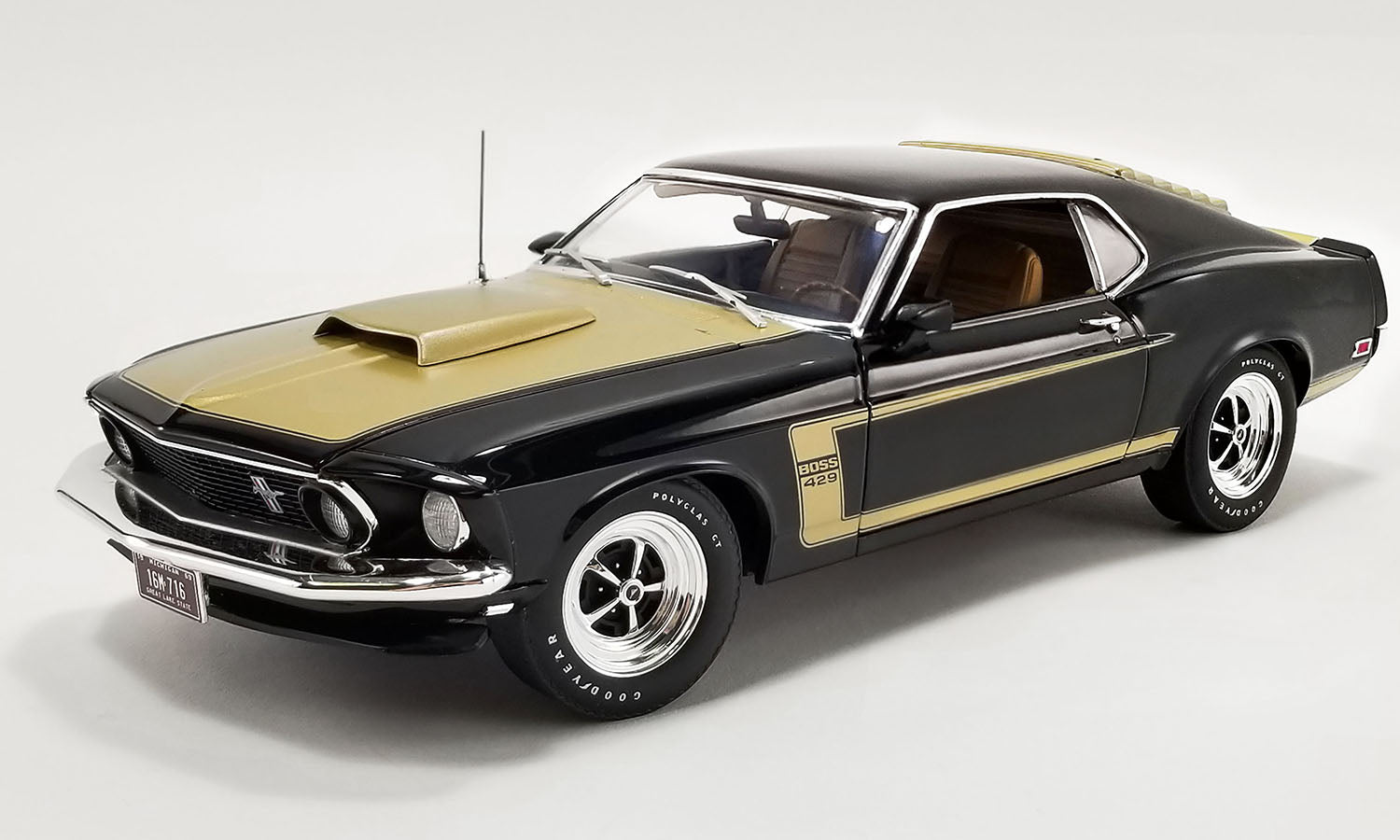 A 1/18 scale diecast model car of a black and gold 1969 Ford Mustang Boss 429.