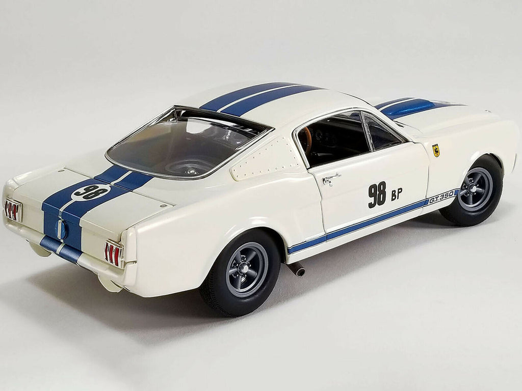 A 1/18 scale model of a 1965 Ford Mustang Shelby GT350R Prototype in white with blue and black stripes and the number 98.