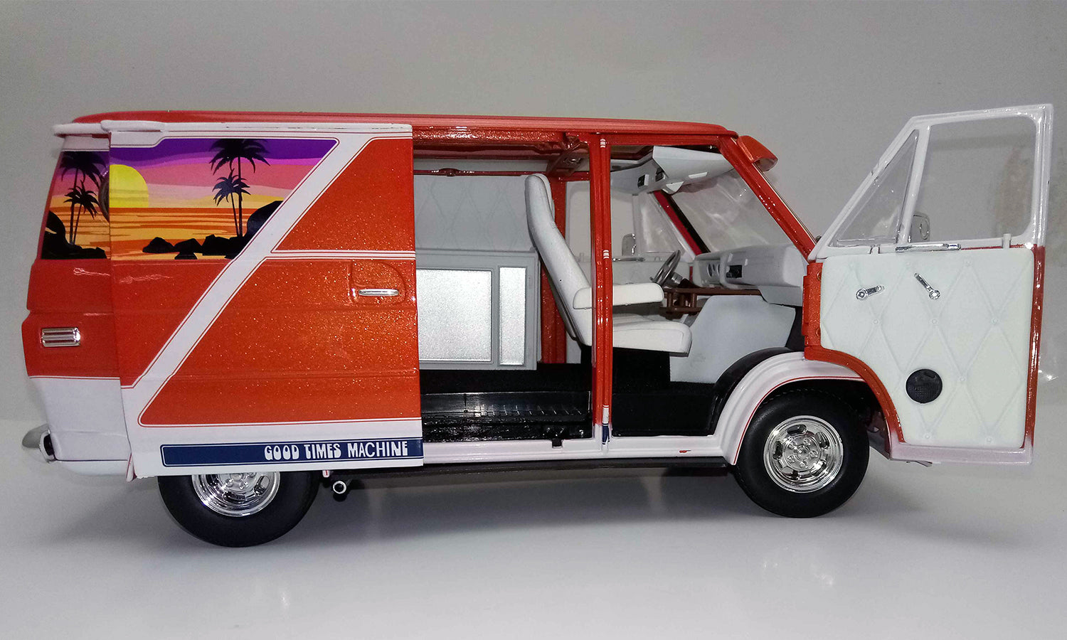 A 1/18 scale model of a red 1976 Chevy G-Series Van with open passenger side doors.