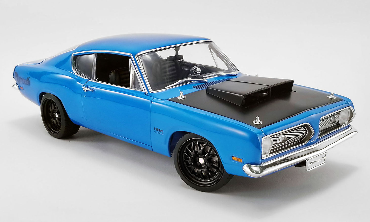 A 1/18 scale model of a 1969 Plymouth Barracuda Street Fighter in blue color with a black spoiler.
