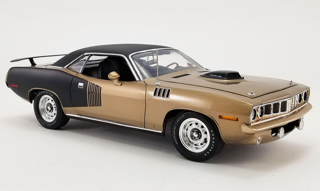 1/18 scale model of a 1971 Plymouth Hemi Barracuda in gold and black with a black vinyl top.