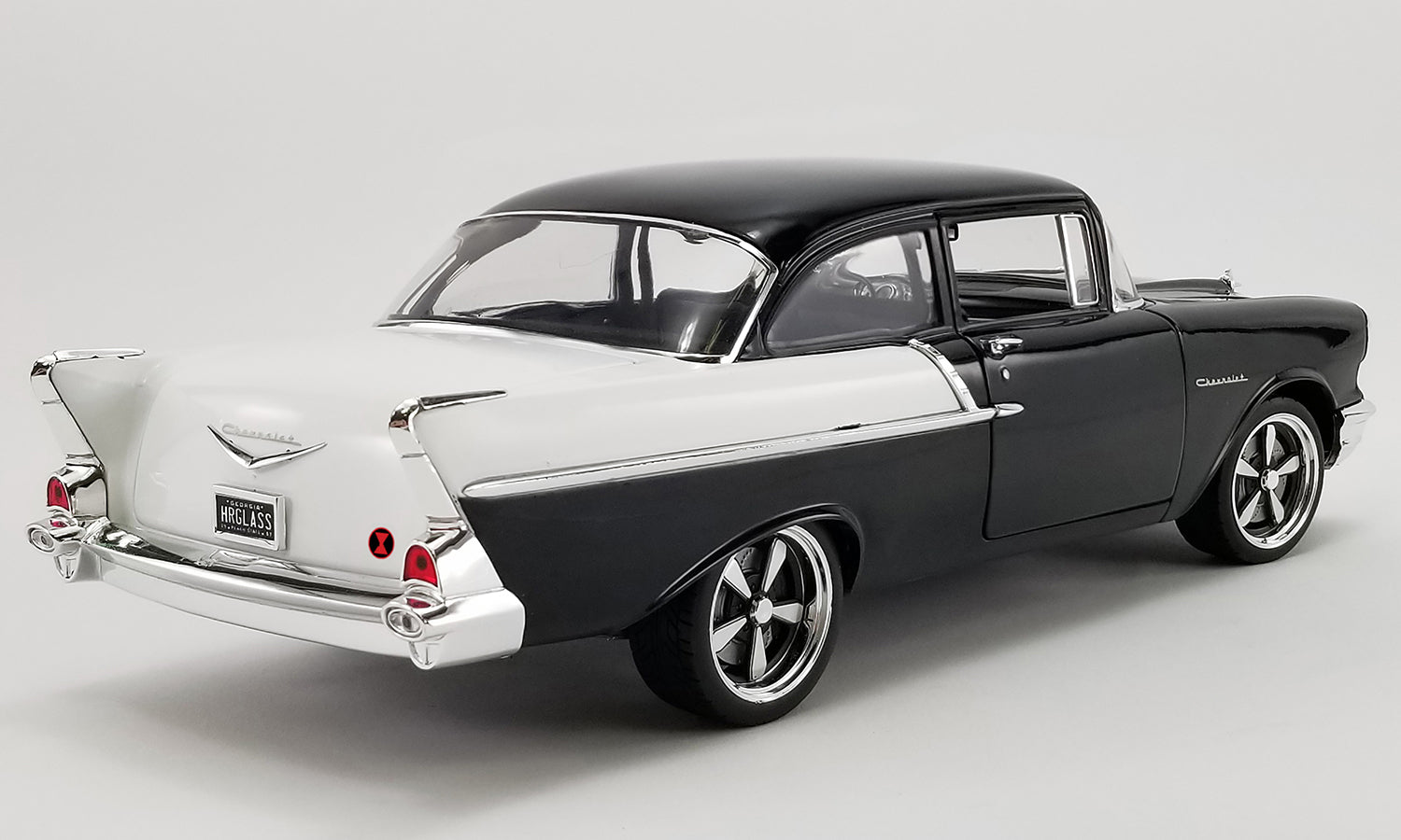 Diecast model car of a black 1957 Chevrolet 150.