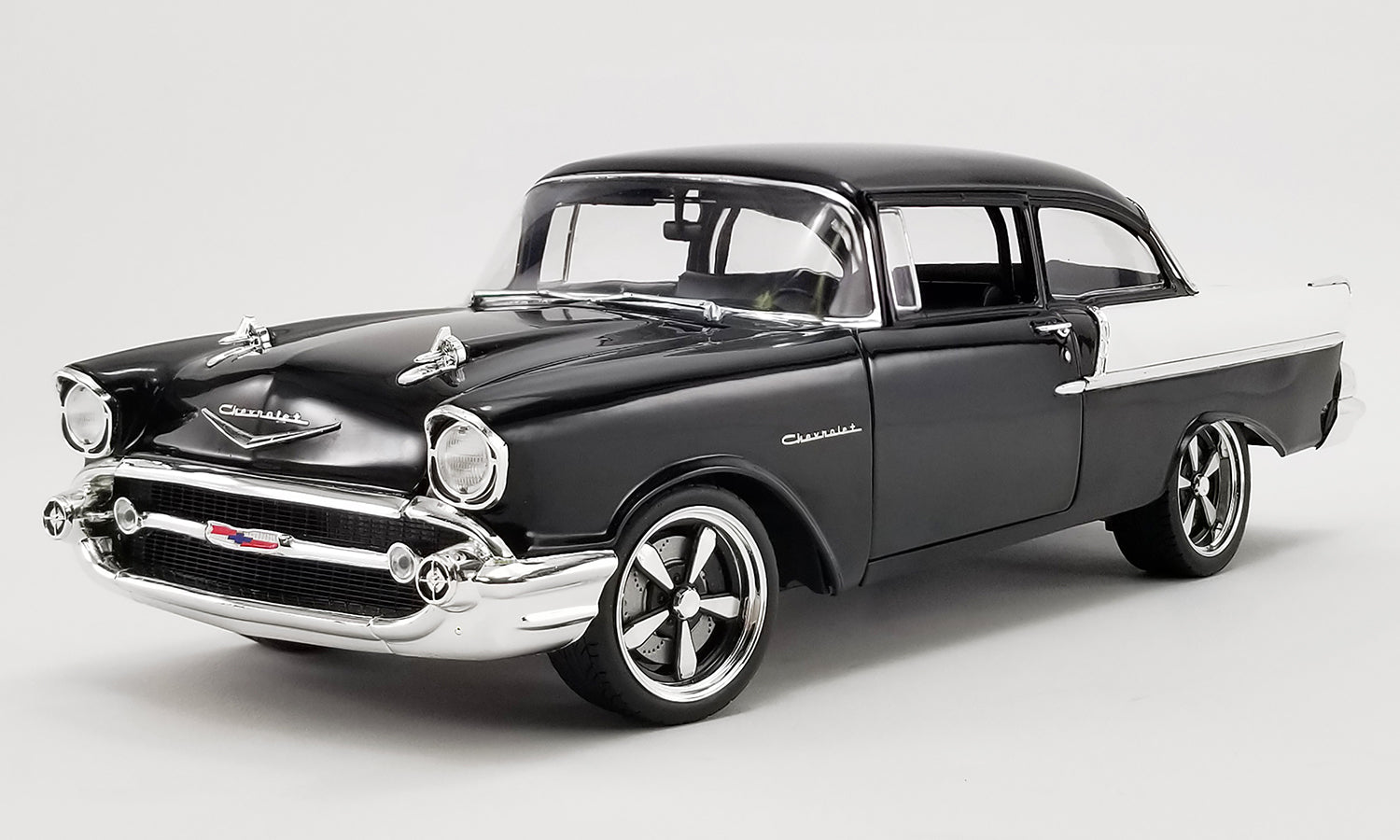 Diecast model car of a black 1957 Chevrolet 150.