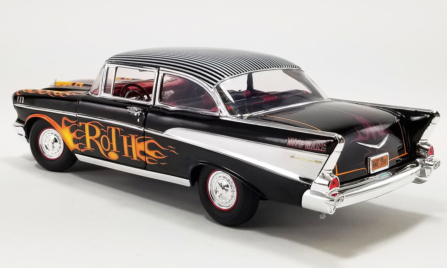 1/18 scale diecast model of 1957 Chevrolet Bel Air in black with flames painted on the sides and hood and "ROTH" on the doors.