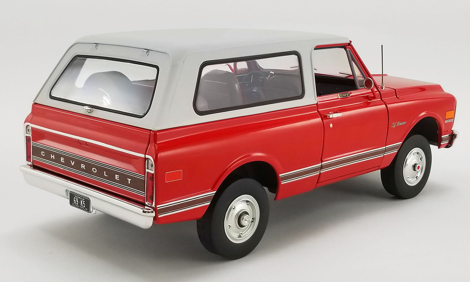 1/18 scale model of a red 1969 Chevrolet Blazer K/5 with white roof.