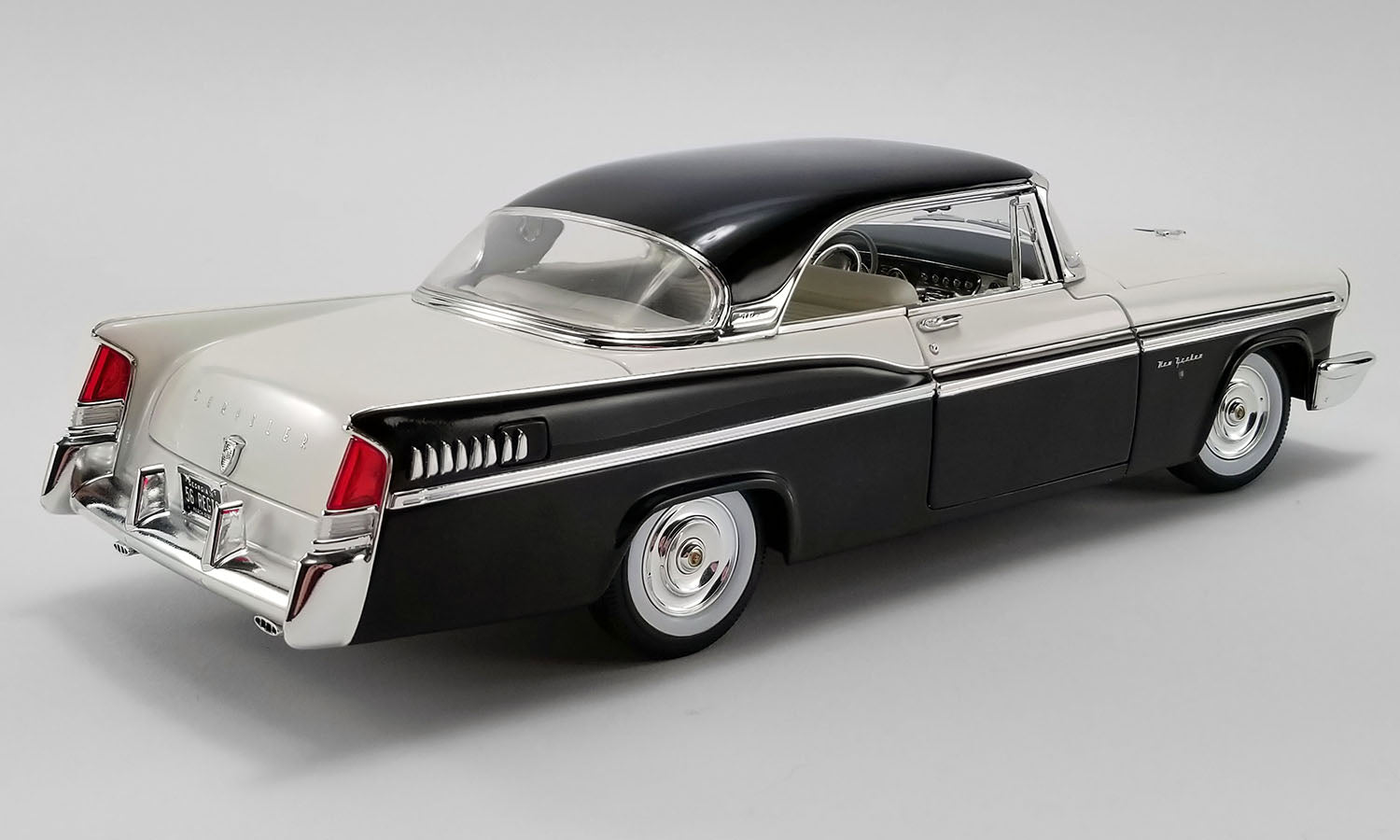 A 1/18 scale model of a 1956 Chrysler New Yorker St. Regis car painted in white and black.