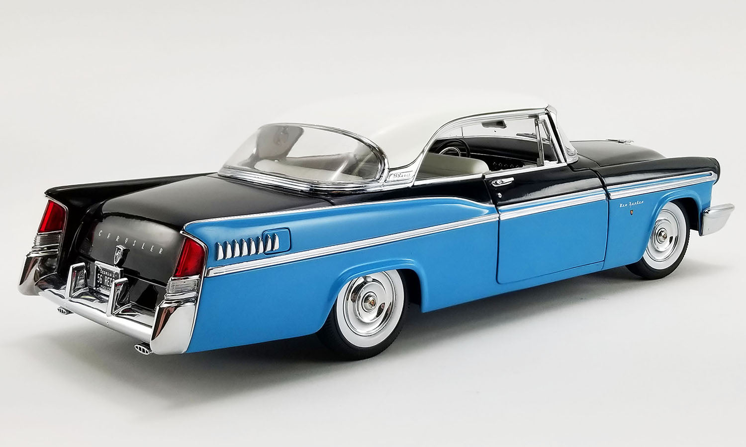 A 1/18 scale model of a 1956 Chrysler New Yorker St. Regis in Stardust Blue and black with a white roof.