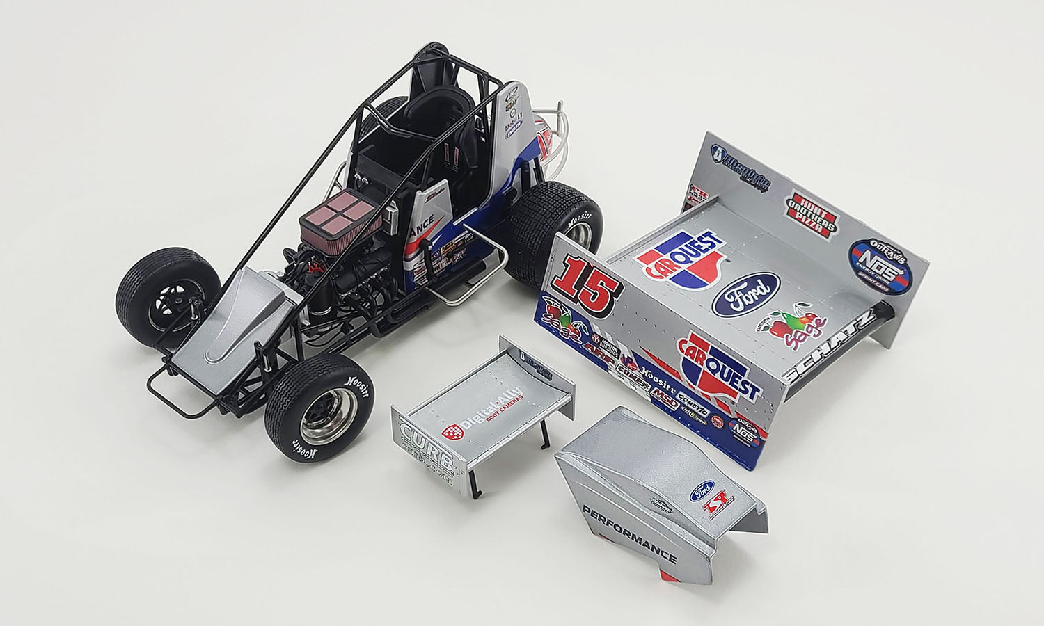 Diecast model of a 2021 Sprint Car with eh wings, engine cover, and roof removed.