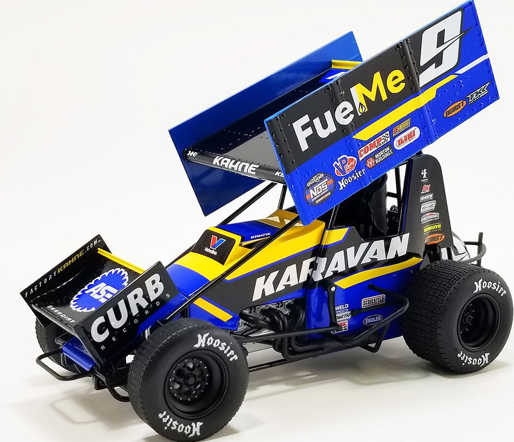 Diecast model of a black, blue, and yellow sprint car with "Fuel Me", "Karavan" and the number 9 on the side.