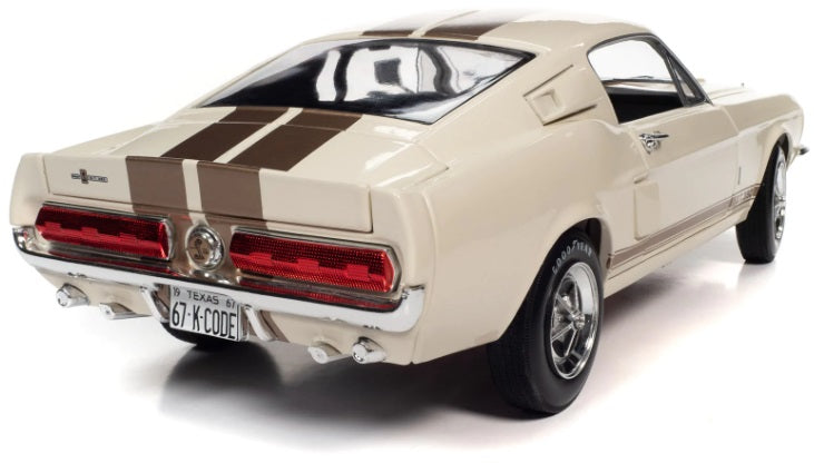A diecast model of a 1967 Shelby GT-350 in white with gold stripes.
