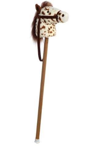 White stick pony with brown spots and brown mane.