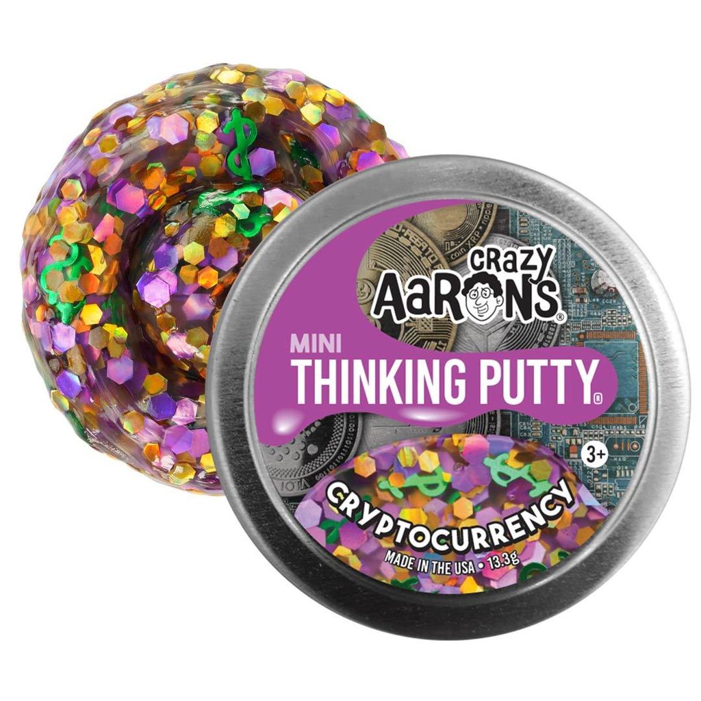 Small metal tin and swirl of putty with purple, gold, and green shapes mixed in.
