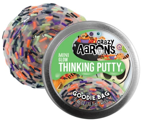 Round metal tin and swirl of clear putty with small colorful pieces mixed in.