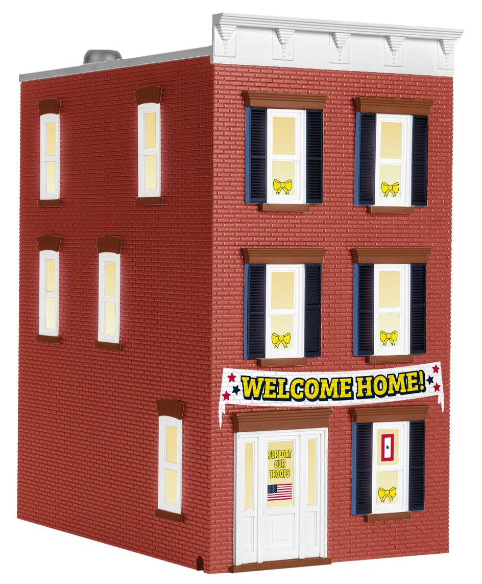 Model of 3 story building with "Welcome Home" banner across the front.