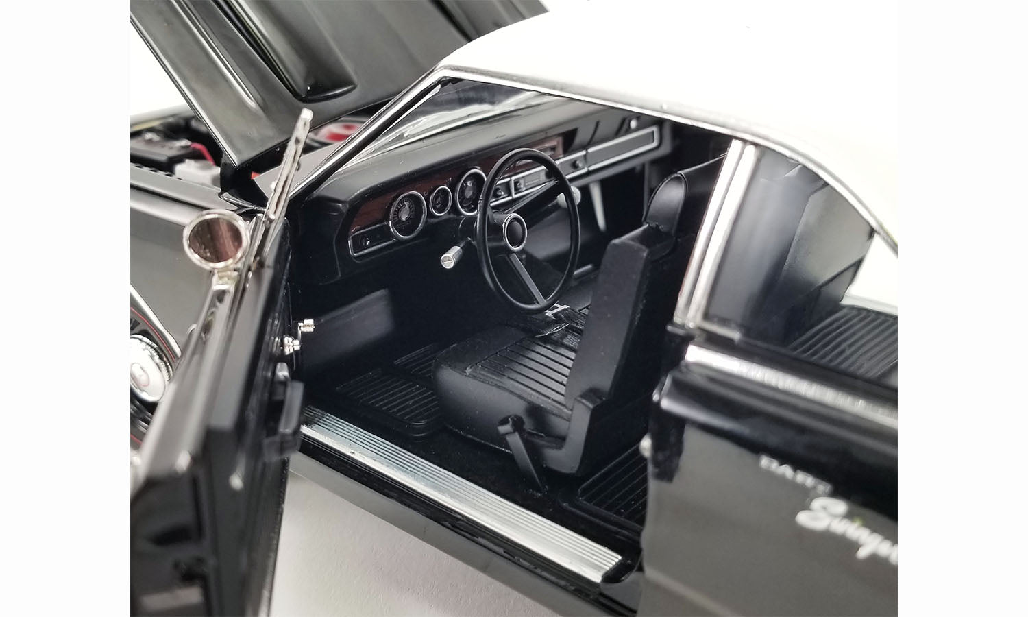 Drivers side detailed interior view of 1/18 scale diecast car of a 1970 Dodge Dart Swinger 340 with a white tail stripe and white vinyl top.
